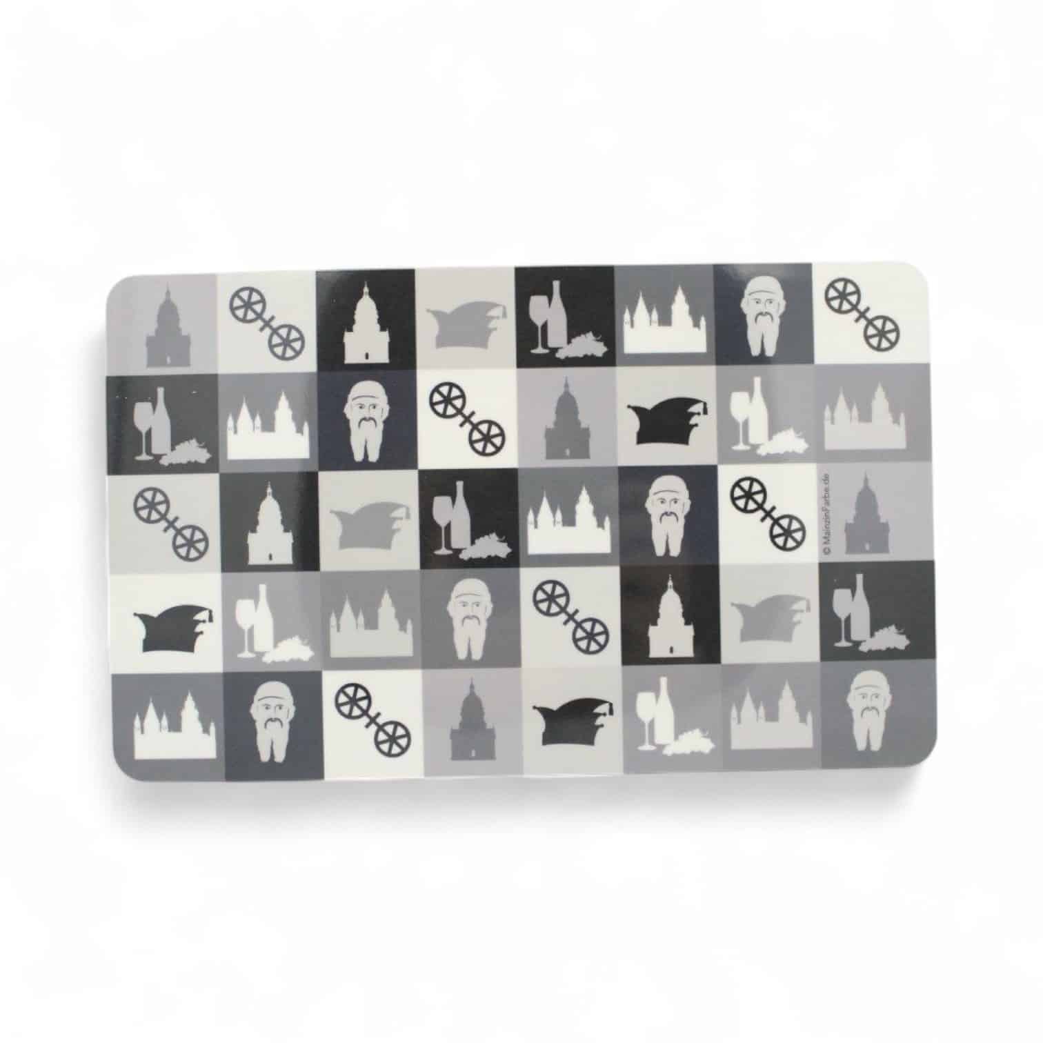 Rechteckiges Plastik-Schneidebrett mit Schachbrettmuster aus Symbolen in Schwarz, Weiß und Grau.