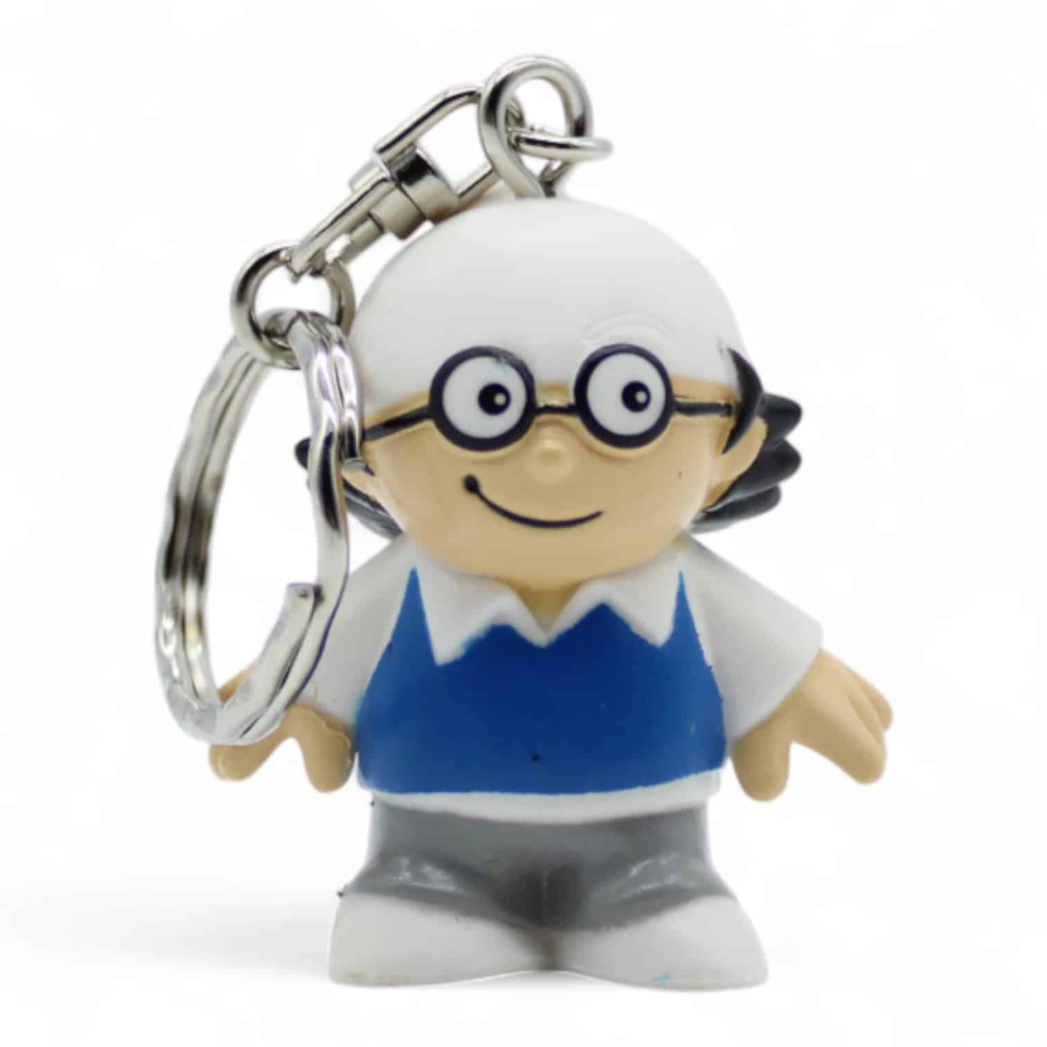 Schlüsselanhänger in Form einer Cartoonfigur mit Brille, weißem Haar und blauem Pullover.
