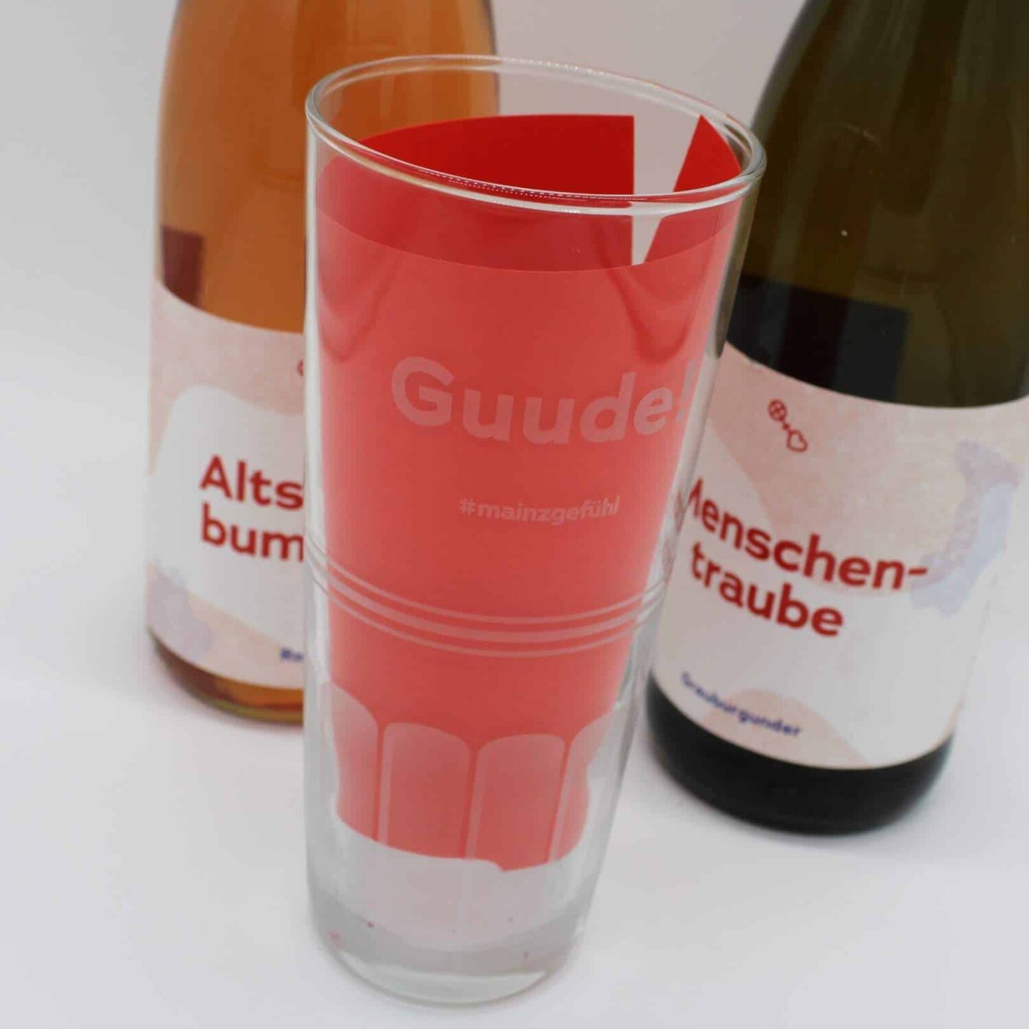Guude Glas neben Weinflaschen