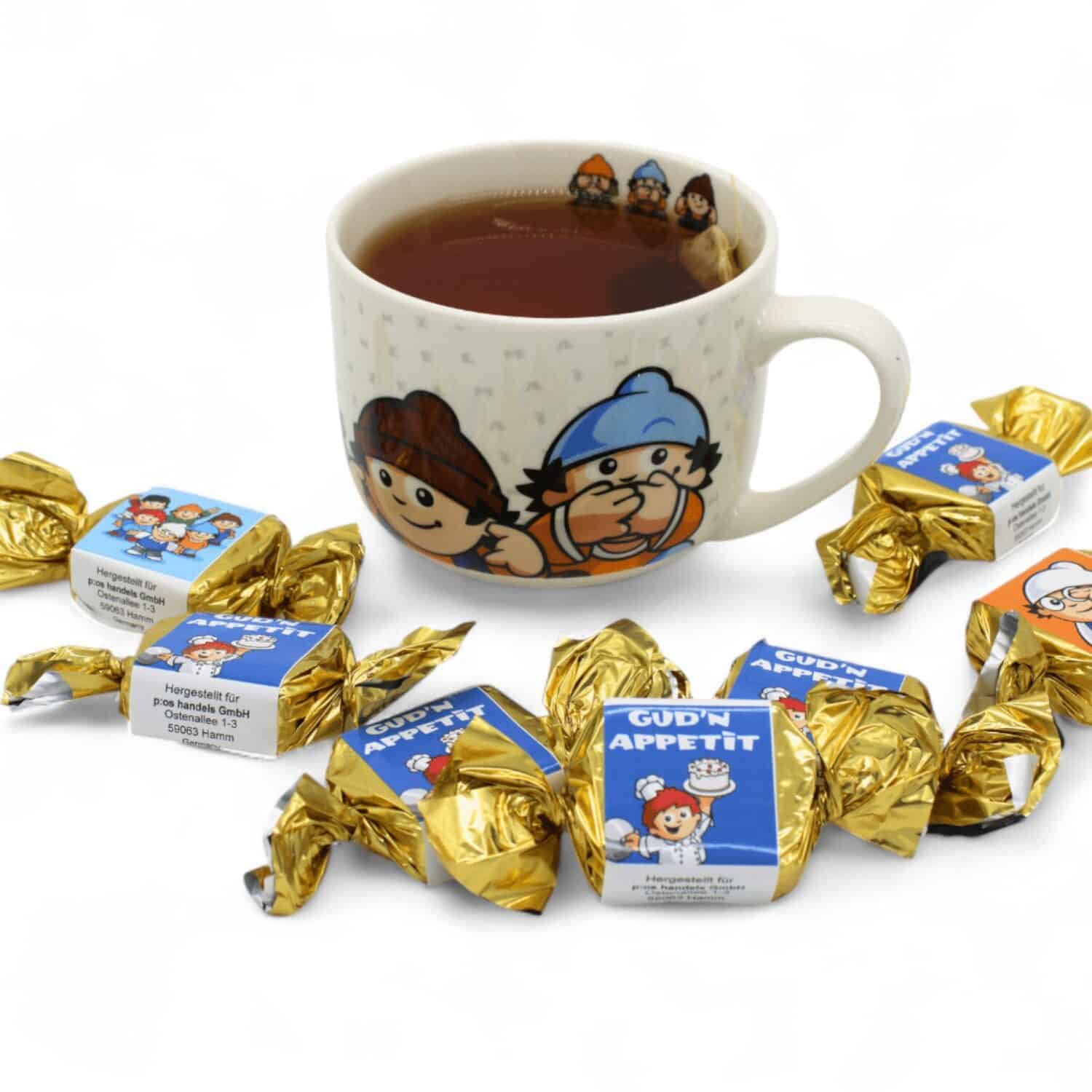 Mehrere Mainzelmännchen Nougathappen mit der Mainzelmännchen Jumbotasse, in welcher Tee ist.